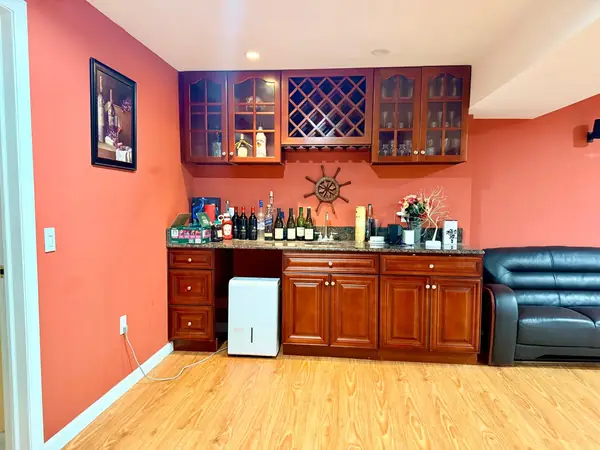 Wet bar cabinetry and glass storage in the basement