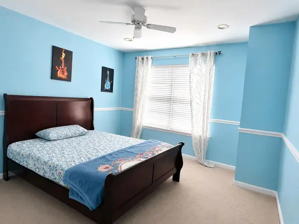 Second bedroom with ceiling fan and window blinds
