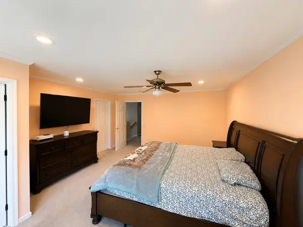 Primary bedroom with sleigh bed and ceiling fan